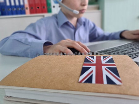 Boy teenager child purposeful working on laptop learns british language. Remote learning of foreign languagesの写真素材