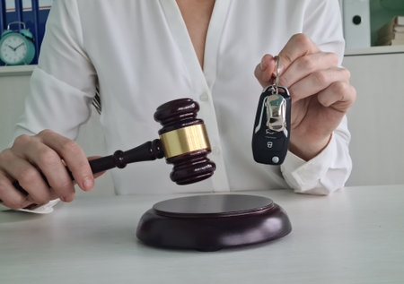 Judge gavel and remote control from car are on table in judge hands. Liability for vehicle theft