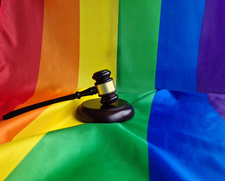 Woden judge gavel symbol of law and justice with lgbt flag in rainbow colors safety and protection. LGBT rights and lawsの写真素材