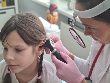 Otolaryngologist examines ear of little girl. Hearing test for childrenの写真素材