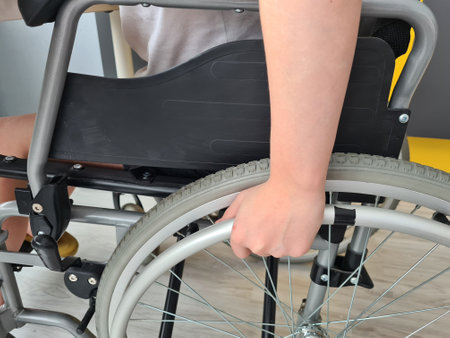 Closeup of child's hand on wheel from wheelchair. Disabled children conceptの写真素材