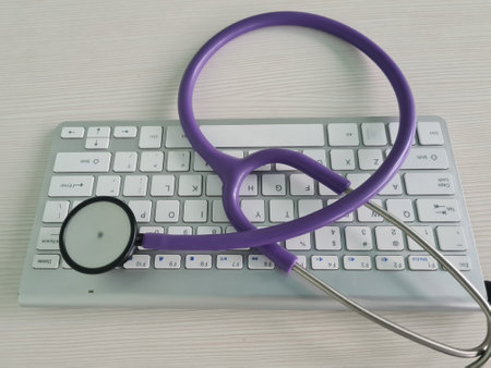 Stethoscope head lying on silver keyboard closeup. telemedicine remote medical careの写真素材