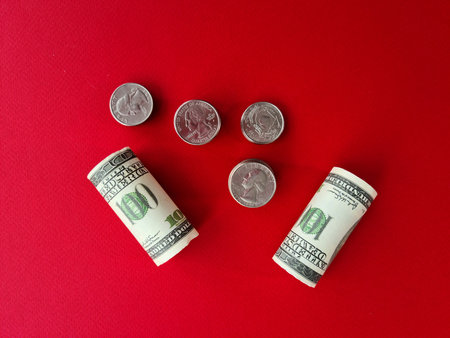 Folded one hundred dollar bill on background of stack of coins. Profitable financial investments and...