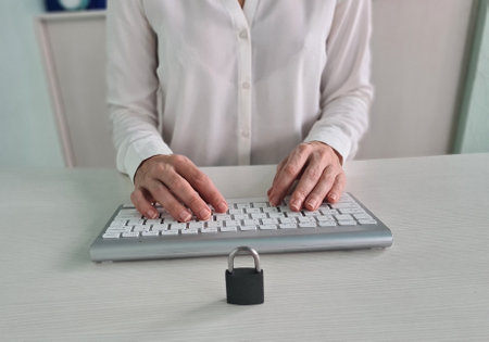 Padlock on laptop computer keyboard and female manager in background. Cyber security, access and...