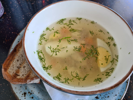 Homemade chicken broth with herbs and egg in white bowl. chicken soup vegetable soup