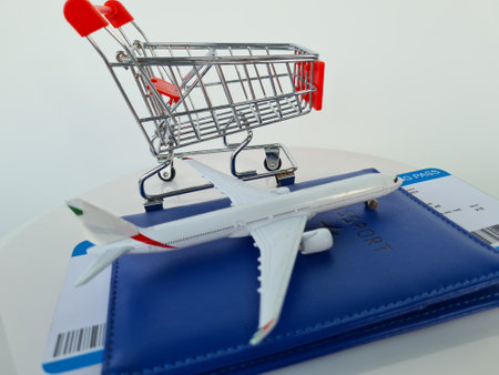 Passport and airplane and shopping basket isolated on white background. Business trip and travel and online shopping conceptの写真素材