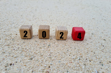 Wooden cube block with 2024 text on old tree stump with blurred background of oceanの写真素材