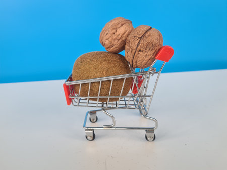 Fresh kiwi walnuts ripe inside in shopping basket. Vitamin healthy vegetarian foodの写真素材
