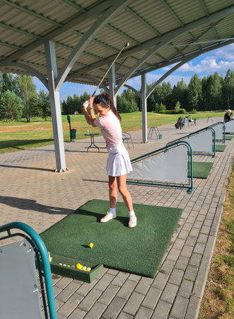 Healthy sport and female golfer training with a golf ball on driving range vertical photo. Lifestyle and sport conceptの写真素材