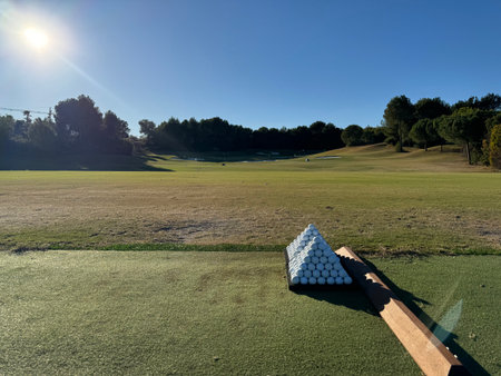 Pyramid of golf balls in driving range with beautiful golf course in backgroundの写真素材