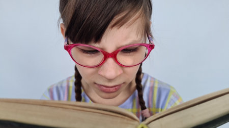 Bookworm with glasses and books poor eyesight reading too much. Vision problems in children and educationの写真素材
