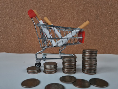 Smoking cost and inflation concept. Cigarettes cart money coins and rising pricesの写真素材