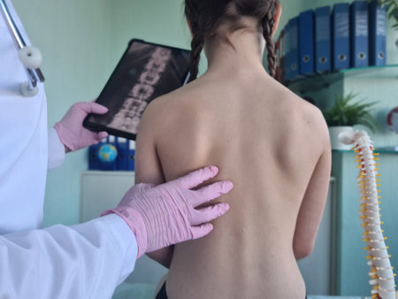 Pediatric surgeon looking at x-ray of child spine. Medic doctor points to x-ray of sick childの写真素材