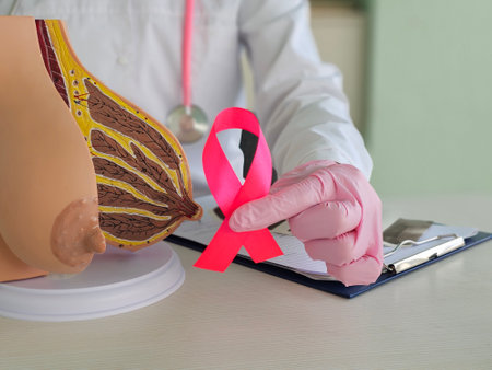 Female gynecologist doctor holds pink ribbon as symbol of breast cancer awareness. Cancer research conceptの写真素材