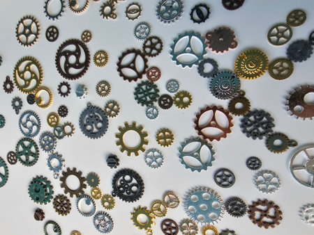 Various metal gears from a disassembled device. Randomly scattered copper and silver parts from...