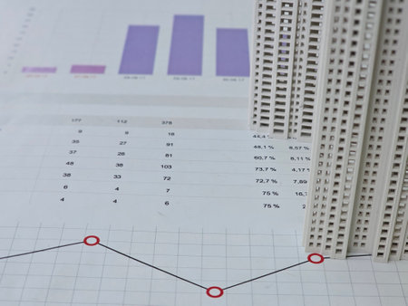 Construction data analysis with scale models and graphs showcasing performance metrics and project planningの写真素材