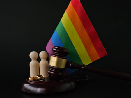 Judge gavel, wedding rings and a rainbow flag symbolize the celebration of marriage equality in a courtroomの写真素材