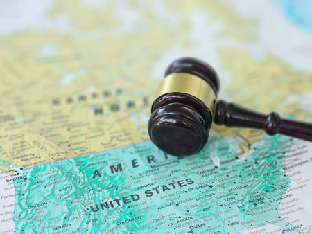 A gavel rests on a detailed map of the United States, symbolizing the intersection of law and...