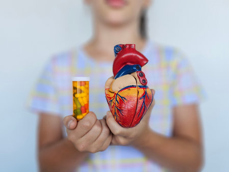 Child holding a colorful heart model and a pill bottle, emphasizing health education and awareness...