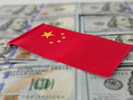Chinese flag on a pile of US dollar bills symbolizing economic ties and international trade dynamics