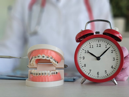 Preparing for orthodontic treatment braces and teeth with an alarm clock. Time wearing braces