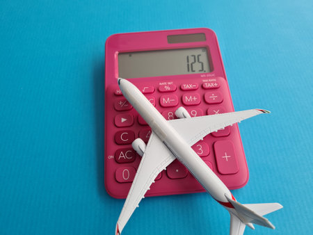 Pink Calculator Next to Toy Airplaneの写真素材