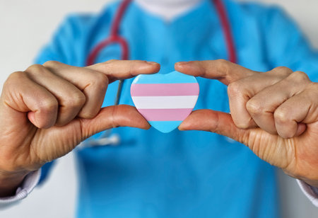 Healthcare professional holds transgender pride heart symbol during awareness campaign in clinic settingの写真素材