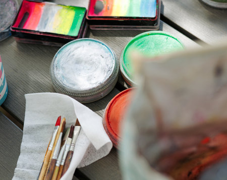 Colorful art supplies arranged on a wooden table ready for painting at a golf course event during...