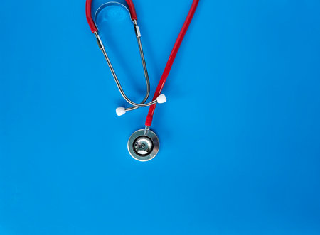 Stethoscope resting on vibrant blue background in a healthcare setting, emphasizing medical professionalism and careの写真素材