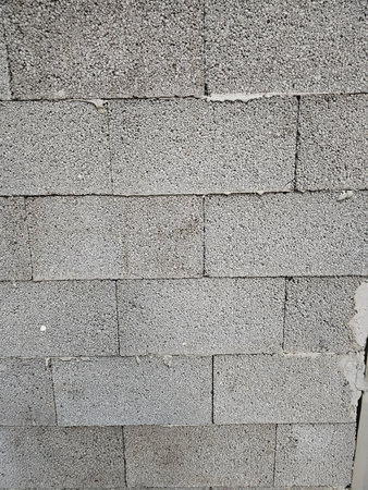 Textured concrete block wall in urban setting showing structural elements and surfaces