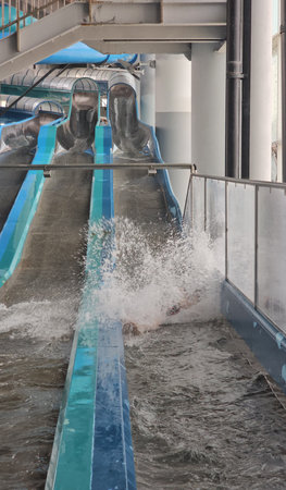 Enjoying a thrilling ride down a water slide at an indoor water park during a summer day