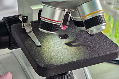 Detailed view of a microscope examining a gemstone specimen in a laboratory setting