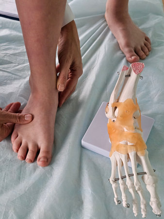 Medical professionals examine a patient foot using an anatomical model for assessment in a clinical...