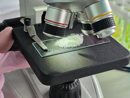 Microscope examination of crystalline sample revealing detailed structure and composition in...