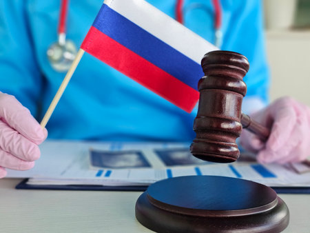 Medical professional holds Russian flag and gavel, symbolizing connection between healthcare and legal matters in Russiaの写真素材