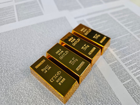 Gold bars displayed on financial newspapers in a well-lit environment showing wealth and investment opportunitiesの写真素材