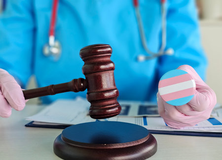 Health professional holds gavel and transgender pride in a legal setting focused on healthcare rightsの写真素材