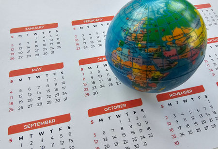 Calendar page with a globe on top showing geographical features and marking months of the year