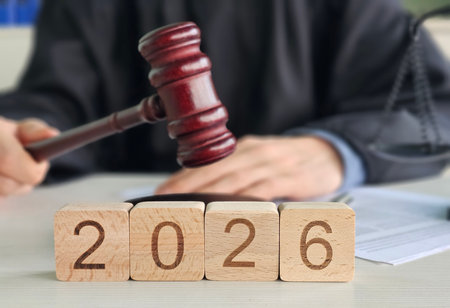 Courtroom scene with a judge's gavel and wooden blocks showing the year 2026, indicating future legal proceedings or decisionsの写真素材