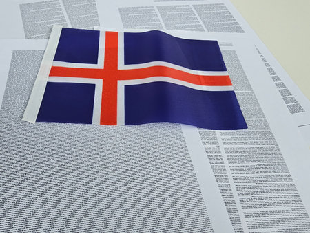 Icelandic flag placed on a backdrop of printed text highlighting cultural significance and national pride in Reykjavikの写真素材