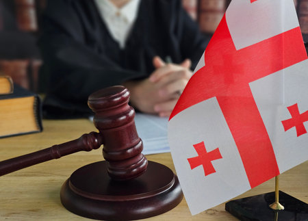 Judge gavel and Georgian flag on desk during court session in a legal settingの写真素材