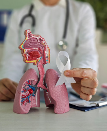 Lung Cancer Awareness Month is November. A doctor with an anatomical model of a smoker lung and a white ribbon in a hospital. Concept for healthcare and World Cancer Dayの写真素材