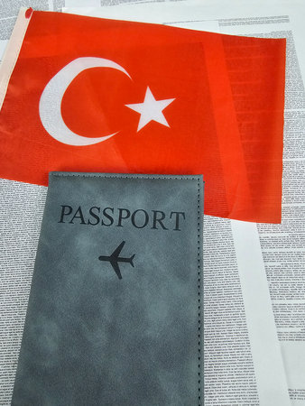 Turkish flag and passport on text background, symbolizing travel and national identityの写真素材