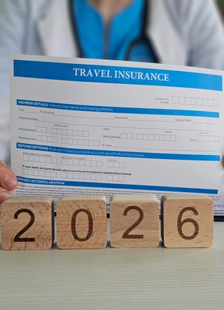 Travel insurance form filling for 2026 with wooden blocks indicating the year