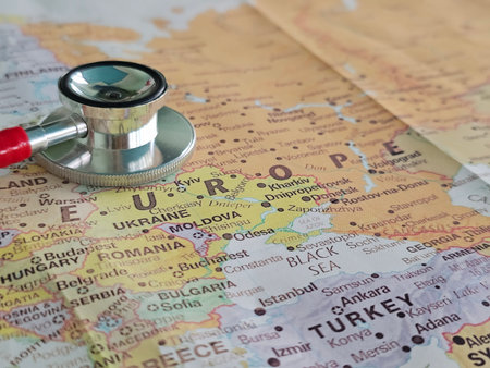Stethoscope placed on a map of Europe highlighting countries and borders for travel health considerationsの写真素材