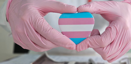 Woman doctor with lgbt heart flag in hand in clinic. Medical assistance to support the LGBT community and transgender peopleの写真素材