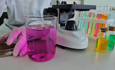 Laboratory experiment with colorful liquids and microscope during science class in a modern lab...