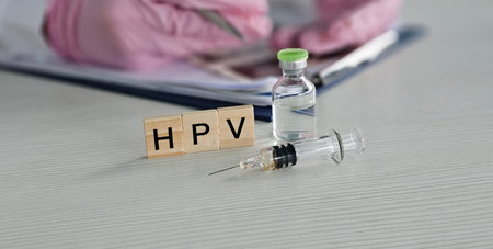 HPV vaccination tools displayed on a clean surface with a healthcare professional preparing to administer the shotの写真素材