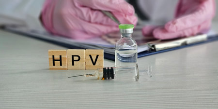 Medical professional preparing HPV vaccine with syringe and vial in clinical settingの写真素材