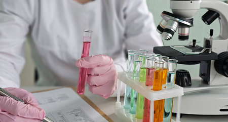 Scientist conducting experiments with test tubes and microscope in a laboratory setting